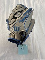 Wilson left handed baseball glove showing front with Wilson logo and blue lacing.
