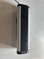 Top view of Pelonis heater showing black front grill and white side panels, plugged in with visible cord.