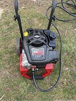 Top view of red and black pressure washer unit with Briggs & Stratton engine and metal frame