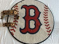 Photo showing the Boston Red Sox round baseball rug alongside the vintage catcher's mask.