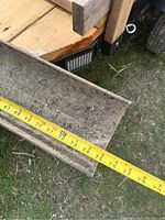 Steel I-beam approximately 75 inches long with visible tape measure showing width about 4 inches. Beam is dirty with some surface grime and spots of rust.