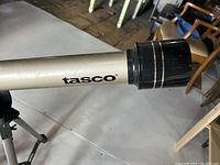 Tasco logo on beige telescope tube close-up.
