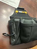 Front view showing various pockets, side loops, and a wire tool holder on the clip-on tool belt.