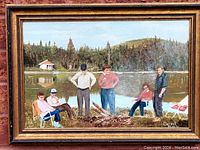 Framed oil painting showing six people by a lake, forest and cottage in background