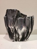 Front view of the signed Brutalist ceramic art sculpture showing its textured surface and black and white glaze.