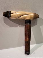Full view of the walking stick handle showing carved bone with sterling silver accents and wooden shaft