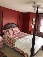 Front view of four post bed with headboard and footboard, showcasing posts, arched headboard, and bedding covering mattress area