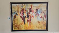 Front view of framed abstract art print on textured canvas with warm brushstroke colors