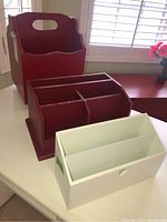 Three wooden desk organizers placed on a white surface near a window with natural light, showing their shape and size.