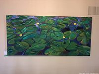 Front view of large green water lily painting on canvas hung on wall.