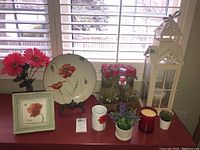 Wide view showing table with poppy decor items including framed print, plate, mug, faux flowers, candle, and lantern.