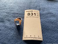 Ring next to maxsold lot tag on blue cloth