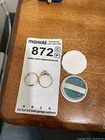 Overhead view showing engagement ring, wedding band and presentation box