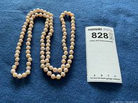 Full view of freshwater pearl necklace alongside MaxSold lot card for size reference.