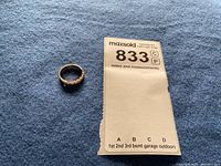 Ring on blue felt beside listing notes tag
