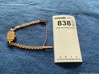 Overall view of the watch laid on blue background with lot tag