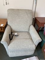 Front view of beige upholstered lift recliner chair