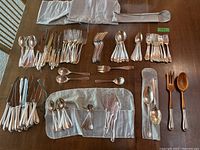 Full layout of all sterling cutlery pieces including silver and wooden-handled items