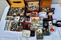 Overview of lot on white cloth showing three wooden boxes and multiple small jewelry boxes filled with various items.