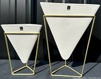 Both Umbra Trigg triangular planters side by side showing size difference and metal frame stands