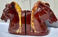 Pair of ceramic horse head bookends in brown with gold mane accents shown side by side.