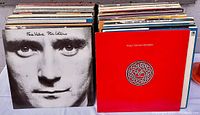 Photo of the front covers of a vinyl record collection showing Phil Collins 'Face Value' and King Crimson 'Discipline' albums at the front.