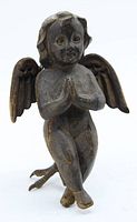 Front view of antique carved wood angel statue showing praying child figure with detailed facial features and attached wings.