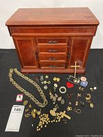 Full view of jewelry box with assorted vintage jewelry laid out in front, showing various sizes and types of items.