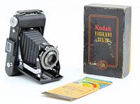 The Kodak Vigilant Six-20 folding camera displayed with its original box and a field guide for metering light exposure.