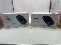 Two boxed Lifepro Legra hand massagers placed side by side on a white surface with a neutral background.