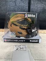 Front side view of signed Philadelphia Eagles Salute to Service mini helmet in clear plastic case showing signature, JSA sticker and card.