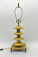 Full view of the vintage modernist brass lamp showing the sculptural body and wood base.