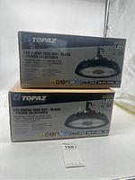 Two boxed Topaz LED Round High Bay black power selectable lights stacked one on top of the other with front box labeling visible.