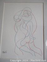 Close-up view of the lithograph image showing red and blue continuous-line drawing of two nude figures embracing.