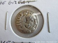 Obverse side of the ancient silver drachm coin showing head of Herakles with lion head-dress.