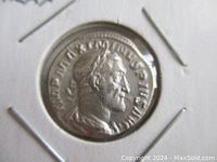 Obverse side of silver coin showing profile bust of Emperor Maximinus Thrax with laurel wreath and inscriptions.