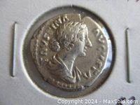 Close-up of the obverse of the silver denarius coin with profile portrait of Empress Faustina the Younger.