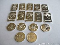 Ten rectangular silver bars and six small round silver coins arranged in rows on a white background.
