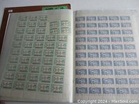 Open binder page showing two stamp sheets in protective sleeves: green portrait issue on left and blue commemorative issue on right