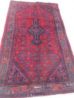 Full view of rectangular red and navy rug laid on surface