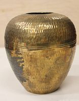 Front angle view of the brass vase showing the hammered texture and patinaed surface