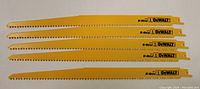 Five yellow DeWalt saw blades arranged horizontally showing teeth and branding.