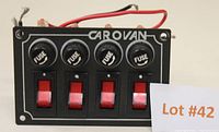 Front view of MotoMaster Carovan fused panel switch showing four fuse caps and four red toggle switches with wiring attached.