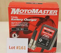 Front of the MotoMaster trickle battery charger box showing unit and clamps, along with brand and voltage information.