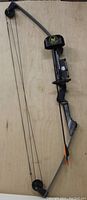 Full view of vintage Outers Blazer compound bow side profile with mounted integrated quiver and one arrow nocked.