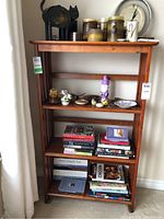 Front view of wooden bookshelf showing three shelves with minor wear.
