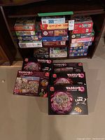 Photo of multiple stacked puzzle boxes arranged on shelves and floor, showing brands and piece counts