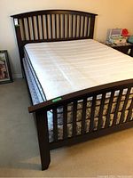 Front view of queen bed frame showing headboard, footboard, mattress on top