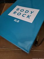Closeup of the blue box packaging showing Body Rock brand and 8lb weight label.