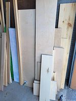 Vertical assortment of plywood sheets, pine boards, MDF and birch veneer panels leaning